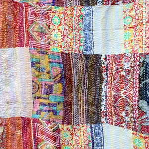 May include: A patchwork quilt made from colourful fabric scraps, featuring a variety of floral and geometric patterns. The quilt is stitched together with a running stitch, creating a unique and textured look.