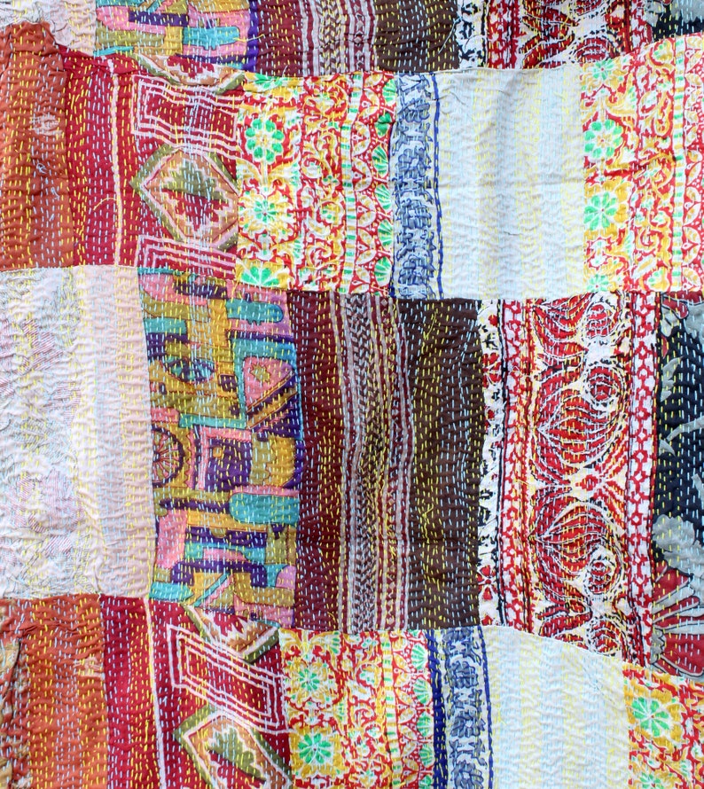 May include: A patchwork quilt made from colourful fabric scraps, featuring a variety of floral and geometric patterns. The quilt is stitched together with a running stitch, creating a unique and textured look.