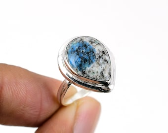May include: A silver ring with a teardrop-shaped blue and white gemstone.