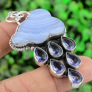 May include: A silver pendant featuring a blue agate cloud with a silver bail and seven amethyst teardrop-shaped stones hanging from the bottom.