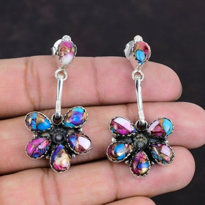 Puede incluir: Un par de pendientes colgantes de plata con un diseño de flor. Las flores están hechas de turquesa multicolor y concha de abulón.
