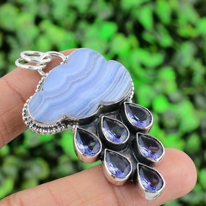 May include: A silver pendant featuring a blue agate cloud with a silver border and seven amethyst teardrop-shaped stones hanging from the bottom.