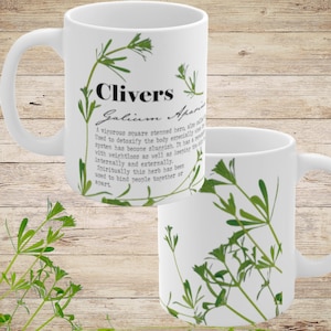 May include: White ceramic mug featuring a green plant illustration and text that reads "Clivers Galium Aparine". A vigorous square stemmed hero, also called cleavers, used to detoxify the body especially when the lymphatic system has become sluggish. It has a reputation for being weightless as well as keeping the body light. Internally and externally. Spiritually this herb has been used to bind people together or apart.