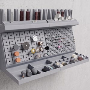 May include: A gray wall-mounted organizer with multiple compartments and storage for various tools and accessories. Features a pegboard design, trays, and slots for holding items like sanding drums, grinding wheels, and other small parts. Ideal for workshop or craft room organization.