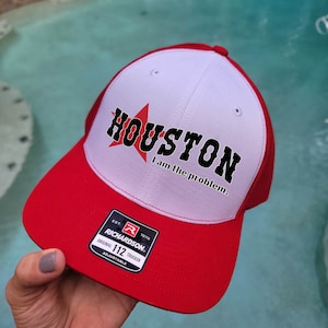 Può includere: Cappellino da camionista rosso e bianco con una stella rossa e il testo "HOUSTON I am the problem." Il cappello ha un'etichetta nera con il testo "EST. 1970 RICHARDSON ORIGINAL 112 TRUCKER ADJUSTABLE."