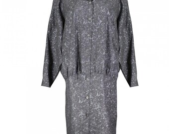 May include: A long-sleeved, button-down shirt dress with a grey and white speckled pattern. The dress has a cinched waist and a relaxed fit.