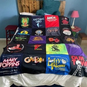 May include: A patchwork quilt made from t-shirts featuring the names of various musicals, including "Mary Poppins", "Annie", "The Wiz", "Pippin", and "Guys and Dolls".