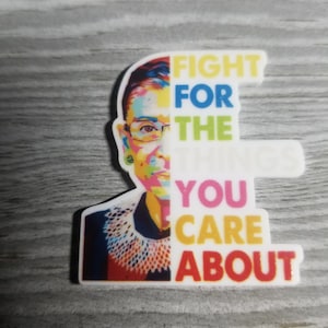 May include: A colorful portrait of Ruth Bader Ginsburg with the text "Fight for the you care about" in a rainbow of colors.