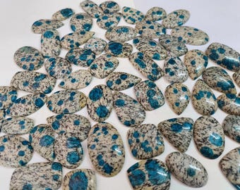 May include: A collection of oval-shaped, polished, natural stones with a white base and blue and black speckles.