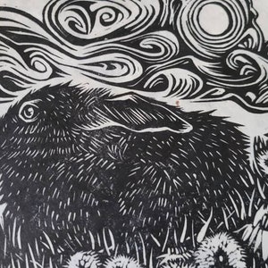 May include: Black and white woodcut print of a rabbit with a swirling cloud above it. The rabbit is surrounded by stylized flowers.
