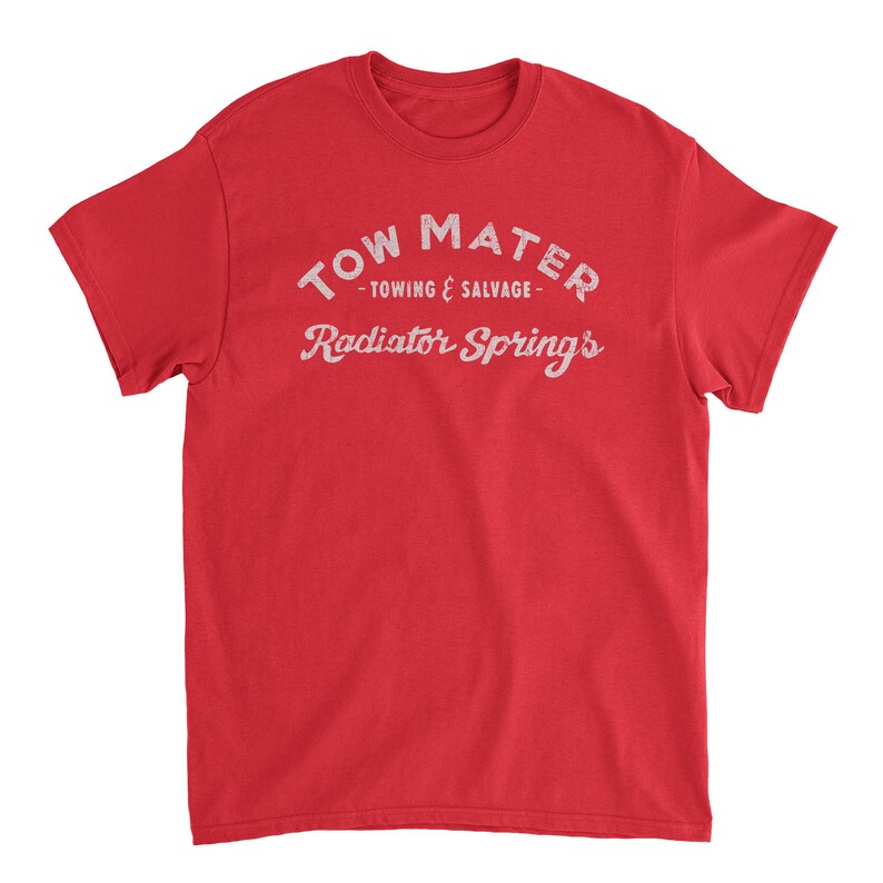 Pu&ograve; includere: Maglietta rossa con testo bianco che recita "Tow Mater - Towing & Salvage - Radiator Springs".