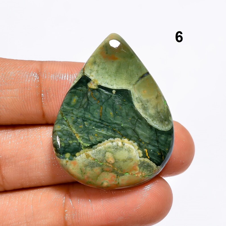 May include: Green, brown and white patterned stone pendant with a teardrop shape. The pendant is approximately 5 cm long.