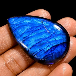 Peut inclure: Une pierre précieuse de labradorite bleue en forme de larme avec des reflets irisés.