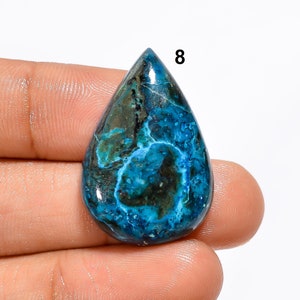Pu&ograve; includere: Una pietra preziosa cabochon a forma di lacrima con un motivo blu e verde. La pietra ha una superficie liscia e lucida ed &egrave; incastonata in una montatura d'argento.