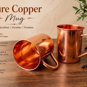 Könnte beinhalten: Zwei glänzende Kupferbecher mit glatten Oberflächen und geschwungenen Griffen. Ein Becher steht aufrecht, während der andere auf der Seite liegt. Der Text auf dem Bild lautet: Pure Copper Mug, Handcrafted | Durable | Timeless, 100% Pure Copper, Handcrafted by Artisans, Durable & Long Lasting, Perfect for Daily Use, Great for Gifting.