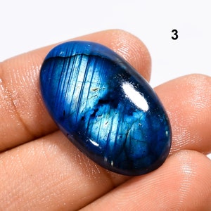 May include: Oval shaped blue labradorite gemstone with iridescent shimmer.