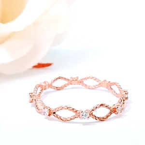 braided ring with diamond in rose gold.