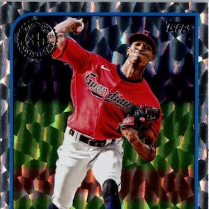 May include: A baseball card featuring Triston McKenzie of the Cleveland Guardians in a pitching pose. He wears a red jersey with "Guardians" across the chest and white pants. The card has a shiny, textured background.