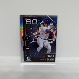 May include: A baseball trading card featuring Drew Gilbert of the New York Mets. The card is chrome with a holographic border and displays the number 60, the words "SIXTY", "POSITION OF", "TEAM NYM", and "TOP 100".