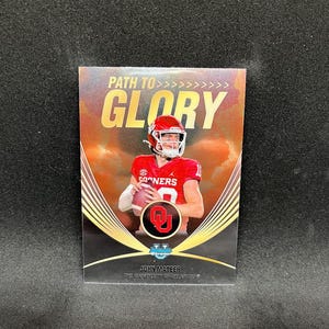 Puede incluir: Tarjeta coleccionable con un jugador de fútbol americano con uniforme rojo, sosteniendo un balón. La tarjeta tiene el texto "PATH TO GLORY" y "JOHN MATEER THE UNIVERSITY OF OKLAHOMA". El fondo es dorado y negro.