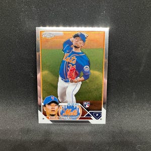 Peut inclure: Carte de baseball avec Kodai Senga des Mets de New York. La carte a une bordure argentée et une photo de Senga lançant en uniforme bleu des Mets. La carte comprend également une petite image de Senga et le logo des Mets.