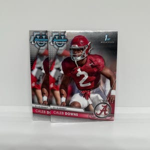May include: Three Bowman Chrome football trading cards featuring Caleb Downs in an Alabama Crimson Tide uniform. The cards have a silver background and the text "1st Bowman" and "Chrome". The player is wearing a crimson jersey with the number 2.