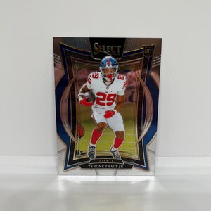 May include: A football trading card featuring Tyrone Tracy Jr. of the Giants. The card has a blue, silver, and gold design with the word "Select" at the top. Tracy is wearing a Giants uniform with the number 29.