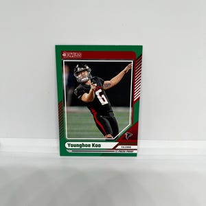 Puede incluir: Una tarjeta de intercambio de fútbol verde, roja y blanca con una foto de Younghoe Koo, un jugador de los Atlanta Falcons. La tarjeta está etiquetada como "Press Proof".