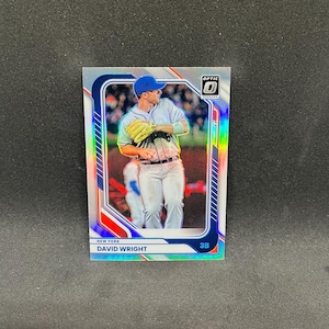 May include: A rectangular sports trading card featuring a baseball player wearing a blue cap and a light gray uniform with a yellow glove. The card has a holographic border with blue and red accents, the text "NEW YORK", "DAVID WRIGHT", and "3B".