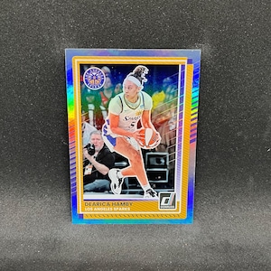 Puede incluir: Una tarjeta de baloncesto coleccionable con Dearica Hamby de Los Angeles Sparks. La tarjeta tiene un borde holográfico y una foto de Hamby en acción, con una camiseta de los Sparks y un balón de baloncesto. El logotipo de Donruss es visible.