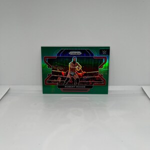 May include: A green, blue, and red trading card featuring a wrestler in a wrestling ring. The card has the words "PRIZM" and "ROBERT ROODE" on it.