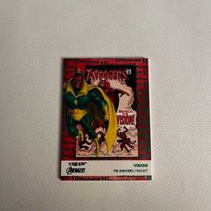 May include: A comic book trading card featuring Vision, a superhero from the Avengers. The card is red, white, and green with a comic book illustration of Vision in a yellow and green costume. The card text reads "Behold... The Vision!" and "The Avengers (1963) #57".