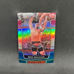 May include: A Bron Breakker wrestling trading card. The card features a holographic design with a wrestler lifting another wrestler. The card has the text "Bron Breakker" at the bottom and "RC" in the upper left corner.