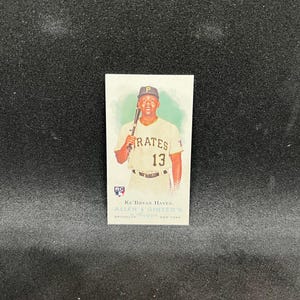 Peut inclure: Une carte de baseball représentant Ke'Bryan Hayes des Pirates de Pittsburgh. La carte montre Hayes en uniforme des Pirates, tenant une batte. La carte porte l'inscription "PIRATES 13" et "ALLEN & GINTER'S".