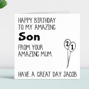 May include: A birthday card with black text on a white background. The card says "Happy Birthday to my amazing Son from your amazing Mum. Have a great day Jacob." There are two black and white balloons with the numbers 2 and 1 on them.