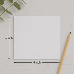 May include: A square white card with smooth edges. Dimension lines indicate a height of 6 inches and a width of 6 inches. A yellow wooden pencil with a sharpened tip is positioned diagonally to the right of the card, and a green leaf is visible.