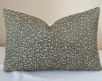 May include: A rectangular decorative cushion with a white interior and a patterned exterior. The exterior features a repeating pattern of olive green and off-white shapes. The cushion is approximately 51 cm long and 30 cm wide.