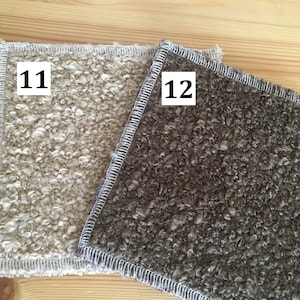 May include: Two square, textured fabric swatches. One is a light beige color, and the other is a dark brown. Both have a white stitched border. The number "11" is in a white box on the beige swatch, and "12" is on the brown swatch.