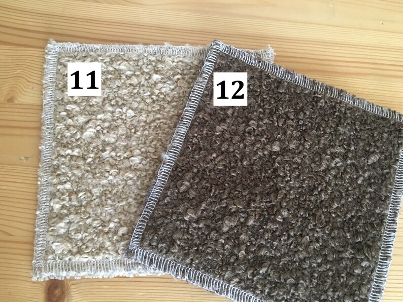 May include: Two square, textured fabric swatches. One is a light beige color, and the other is a dark brown. Both have a white stitched border. The number "11" is in a white box on the beige swatch, and "12" is on the brown swatch.