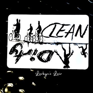 Puede incluir: Ilustración en blanco y negro de tres personas montando en bicicleta con la palabra "CLEAN" escrita encima. La imagen se refleja al revés debajo de la palabra "CLEAN". El texto "Larkyn's Lair" está escrito debajo de la imagen.