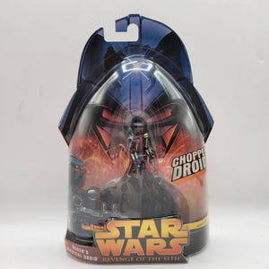 以下が含まれることがあります： スターウォーズのチョッパー・ドロイドのアクションフィギュア。オリジナルのパッケージには、スターウォーズのロゴと「Revenge of the Sith」の文字が描かれています。フィギュアは、暗い配色で、ドロイドを詳細に表現した小さなものです。