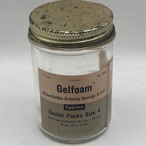 May include: A clear glass jar with a rusty metal lid. The label reads "Gelfoam Absorbable Gelatin Sponge U.S.P." and "Dental Packs Size 4." Each pack is approximately 20 mm x 20 mm and 7 mm.
