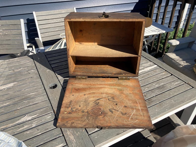 May include: A wooden box with a hinged lid and a shelf inside. The box is open and the inside is empty. The box is made of natural wood and has a rustic look.