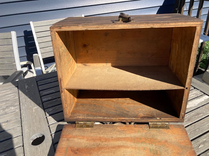 May include: A wooden box with a hinged lid and a shelf inside. The box is made of dark wood and has a natural finish. The box is open and the inside is empty.