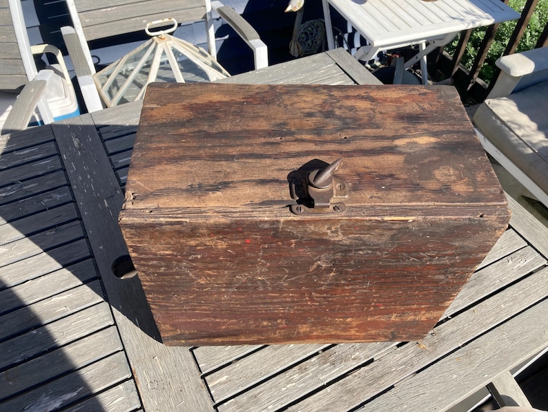 May include: A vintage wooden box with a metal latch and a worn brown finish. The box has a hinged lid and is made of solid wood.