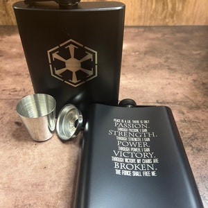 May include: Black metal flask with a Star Wars Imperial symbol on one side and a quote about the Force on the other side. The quote reads: "Peace is a lie. There is only passion. Through passion I gain strength. Through strength I gain power. Through power I gain victory. Through victory my chains are broken. The Force shall free me."