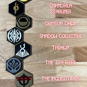 May include: A set of eight hexagonal game tokens with different symbols and colours. The tokens are arranged vertically on a wooden surface. The text on the tokens reads: "Jedi Temple Guard", "Chandrila Starliner", "Crimson Dawn", "Shadow Collective", "Thrawn", "The 7th Fleet", and "The Inquisitorious".