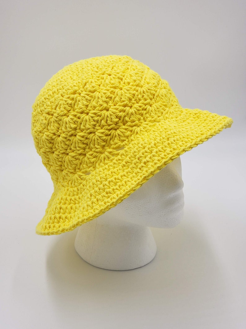 May include: A bright yellow crocheted sun hat with a wide brim.