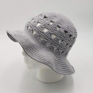 May include: A grey crocheted sun hat with a wide brim and a pattern of openwork triangles.