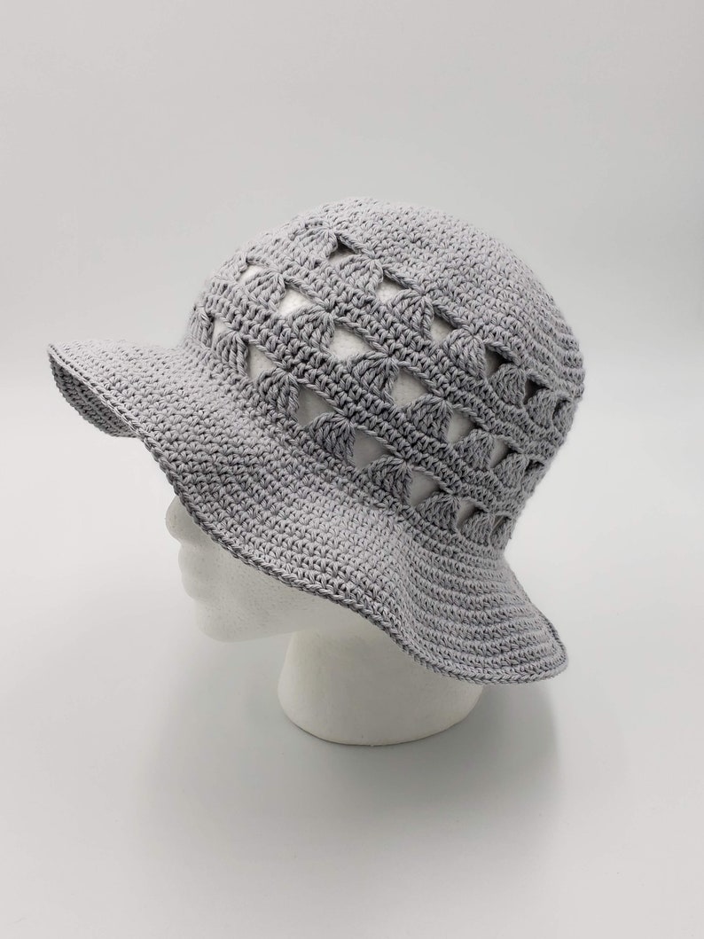 May include: A grey crocheted sun hat with a wide brim and a pattern of openwork triangles.